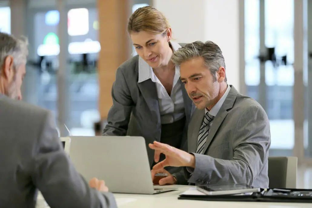 Business man and woman in a meeting looking at laptop